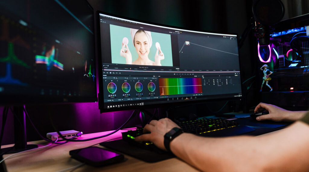 Gros plan sur une main manipulant une souris pour ajuster une timeline de montage vidéo, avec interface floue en arrière-plan